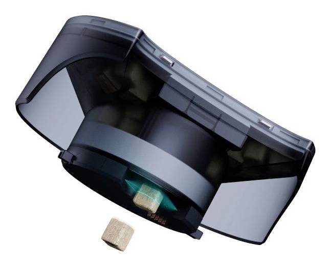 Un petit appareil électronique noir et compact distribue un petit cube en bois par son ouverture.