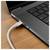 Câble USB-C branché sur le côté d'un ordinateur portable sur un bureau en bois, montrant l'appareil en cours de chargement ou connecté.
