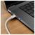 Gros plan du côté d'un ordinateur portable avec un câble de charge blanc branché sur le port sur un bureau en bois.