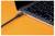Gros plan du côté d'un ordinateur portable avec un câble branché dans un port sur une surface orange.