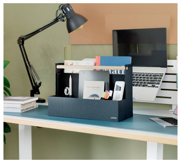 Espace de travail de bureau avec ordinateur portable, lampe noire et organiseur contenant des livres et des fournitures de bureau.
