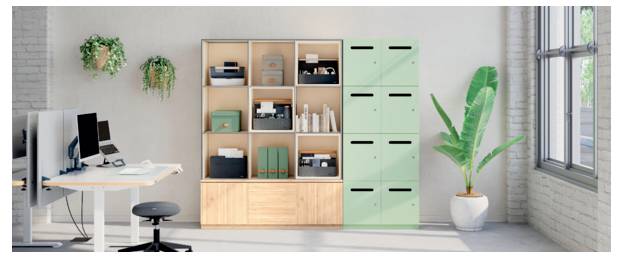 Intérieur de bureau moderne avec des bureaux, des moniteurs d'ordinateur, des étagères, des casiers de rangement menthe, et une plante en pot près de grandes fenêtres.