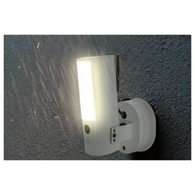 Luminaire LED extérieur mural blanc brillant sur un mur extérieur texturé la nuit.