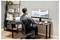 Personne travaillant à un bureau avec deux moniteurs affichant des graphiques et des diagrammes d'analyse de médias sociaux, utilisant une souris et un ordinateur portable dans un bureau à domicile.