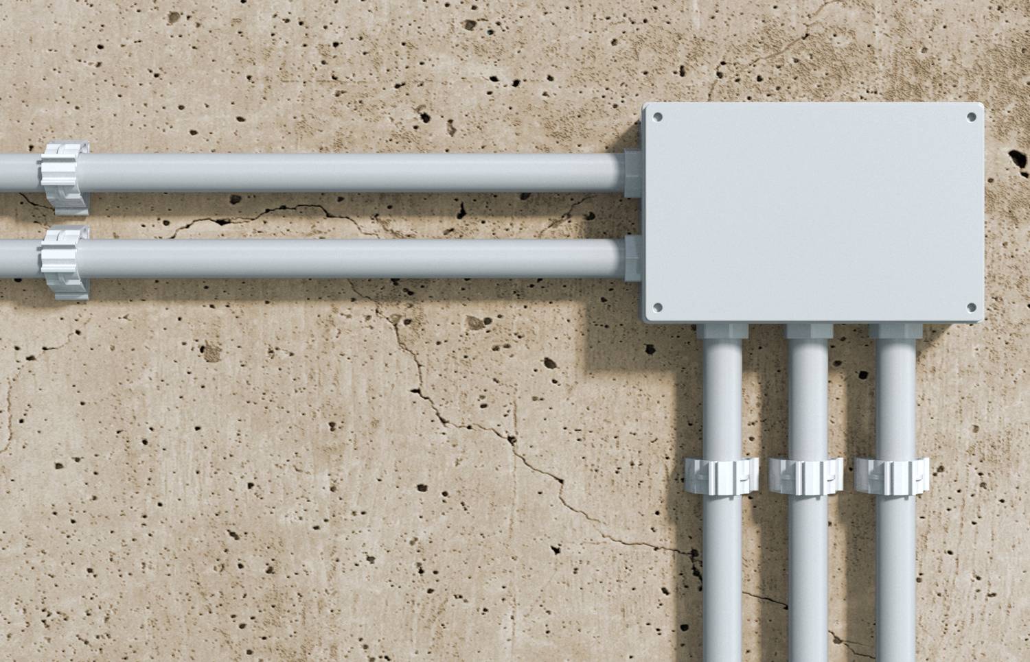 Un conduit électrique entre dans une boîte de jonction grise montée sur un mur en béton fissuré.