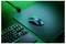 Souris sans fil sur un grand tapis de souris à côté d'un clavier compact sur un bureau éclairé en vert.