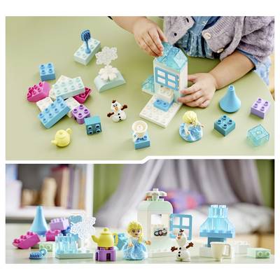 Enfant jouant avec des cubes de construction colorés et de petites figurines, assemblant une petite structure ressemblant à une maison sur une surface de table.