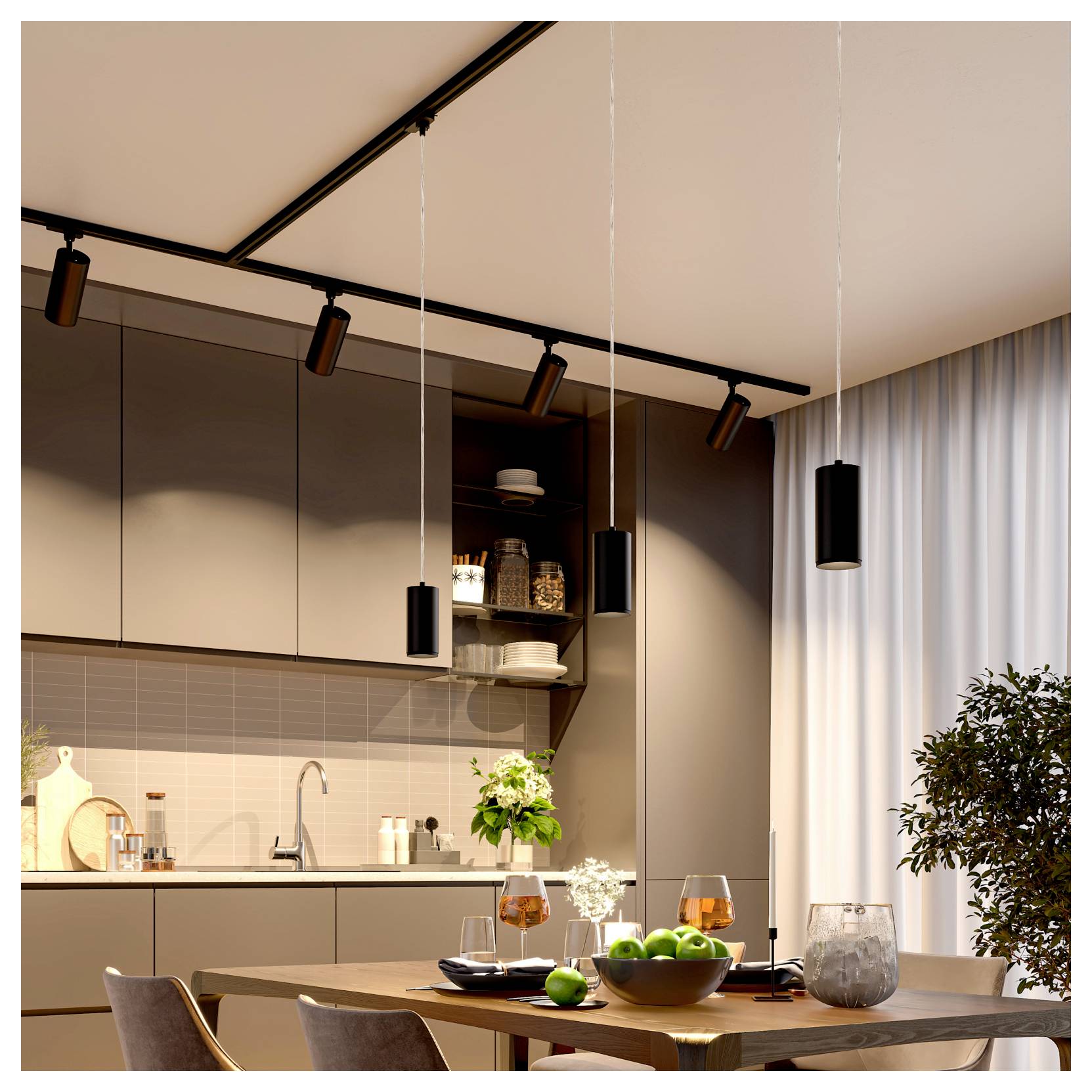 Cuisine et salle à manger modernes avec suspensions et éclairage sur rail, une table dressée avec des fruits et des boissons, des placards, un évier et de grands rideaux près d'une fenêtre.