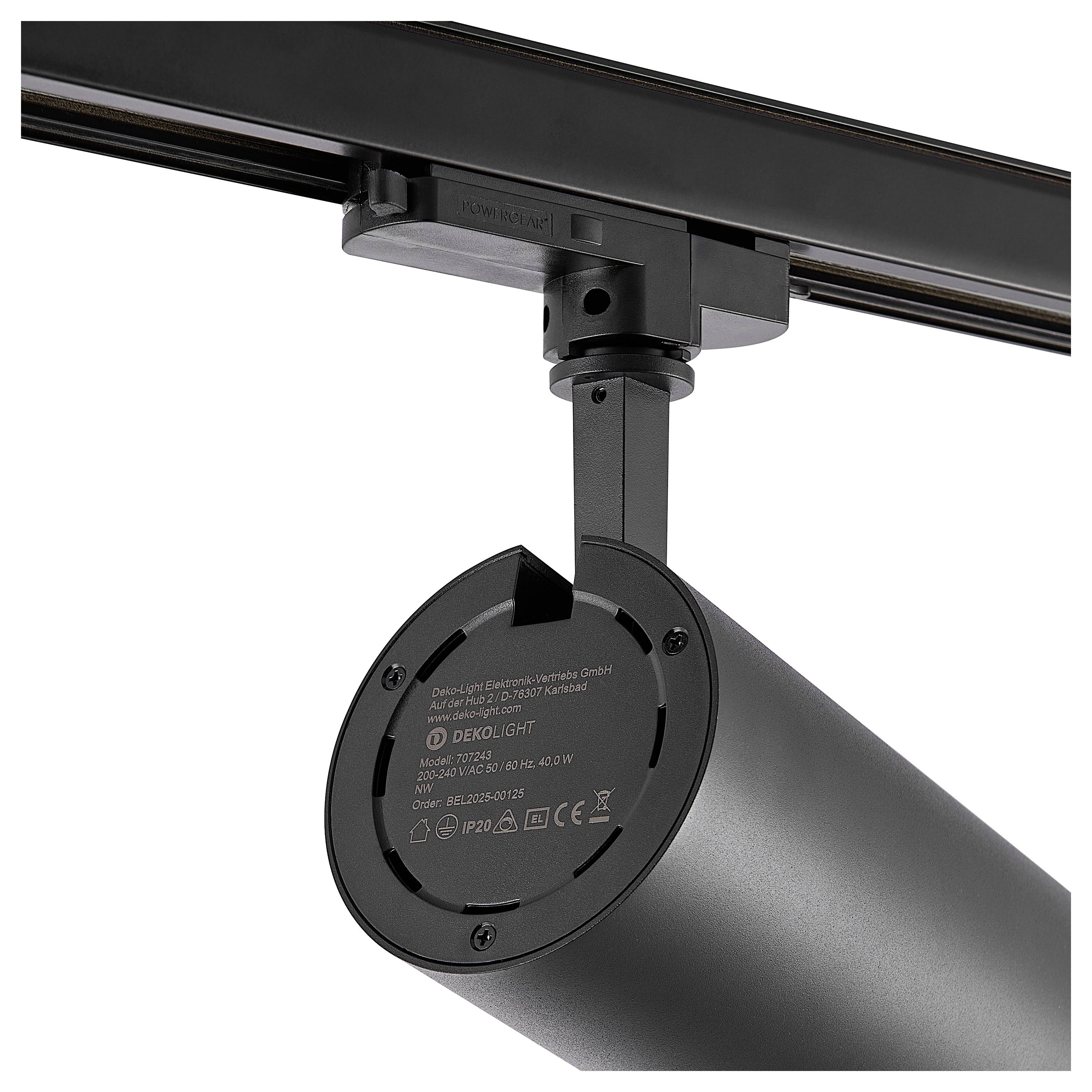 Projecteur cylindrique noir montés sur un rail de plafond, présenté en gros plan sur un fond blanc.