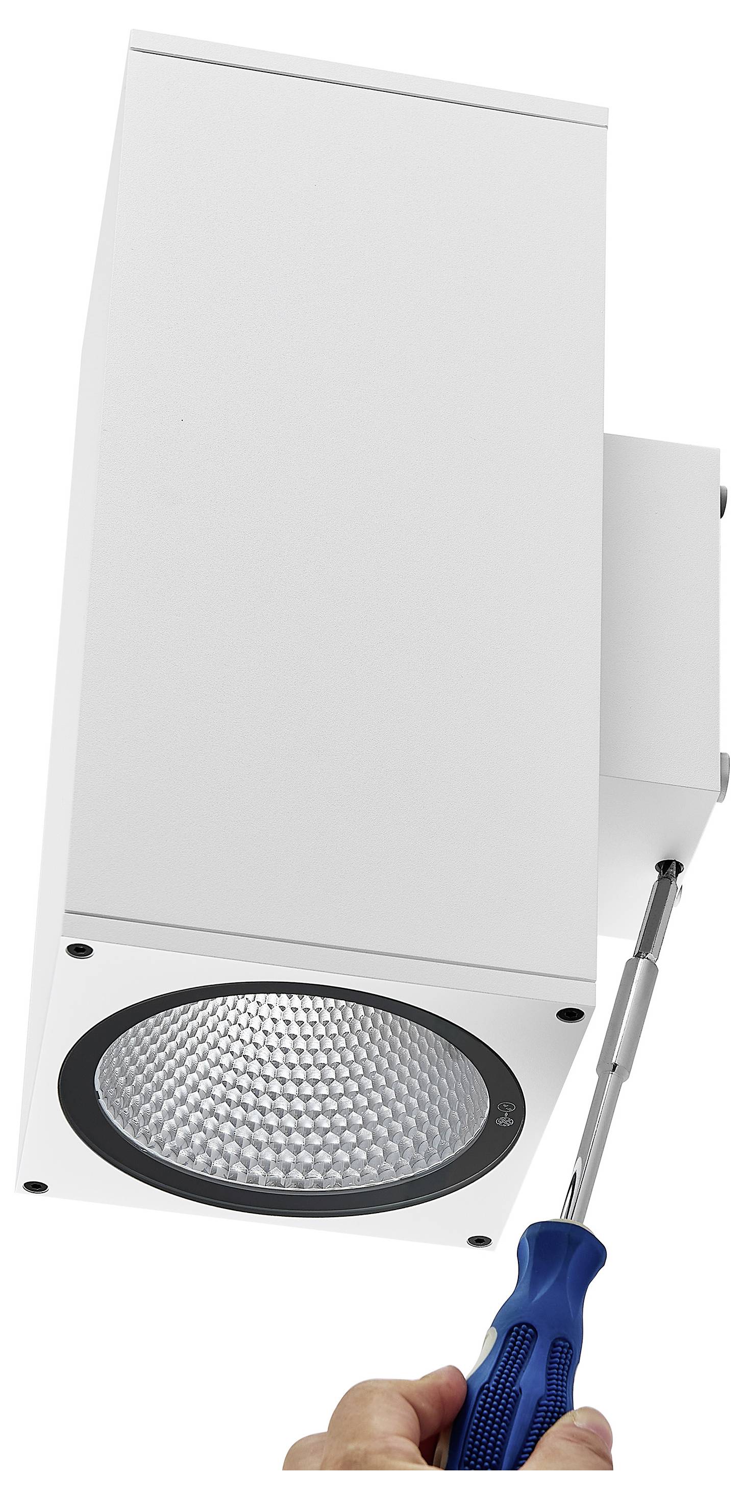 Main utilisant un tournevis pour installer un luminaire de plafond rectangulaire blanc avec une lentille LED ronde.