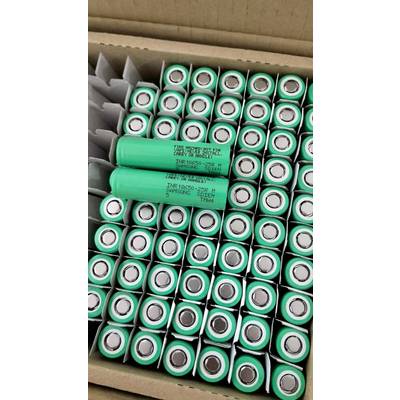 Boîte de cellules de batterie cylindriques vertes emballées dans du carton, avec quelques cellules étiquetées et disposées sur le dessus.