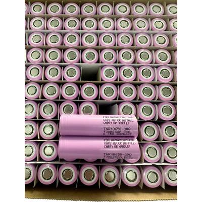 Pile de batteries lithium-ion cylindriques roses, avec deux cellules étiquetées « INR18650-30Q » posées au centre.