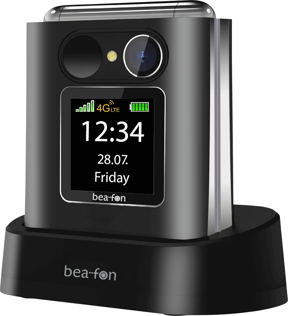 Téléphone à clapet fermé sur un socle de charge, affichant l'écran de face avec l'heure 12:34, la date 28.07., vendredi, les icônes de signal 4G LTE et de batterie.
