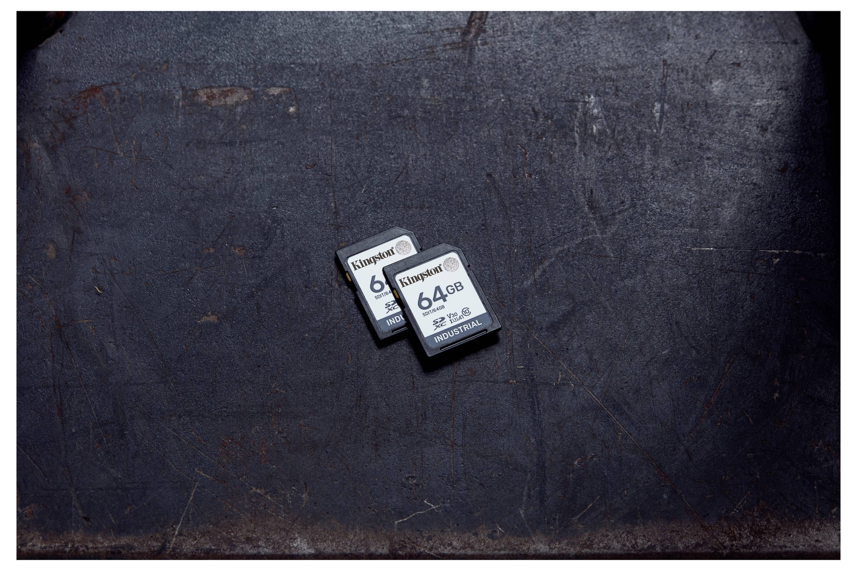 Deux cartes mémoire SD Kingston de 64 Go se chevauchant sur une surface texturée foncée.