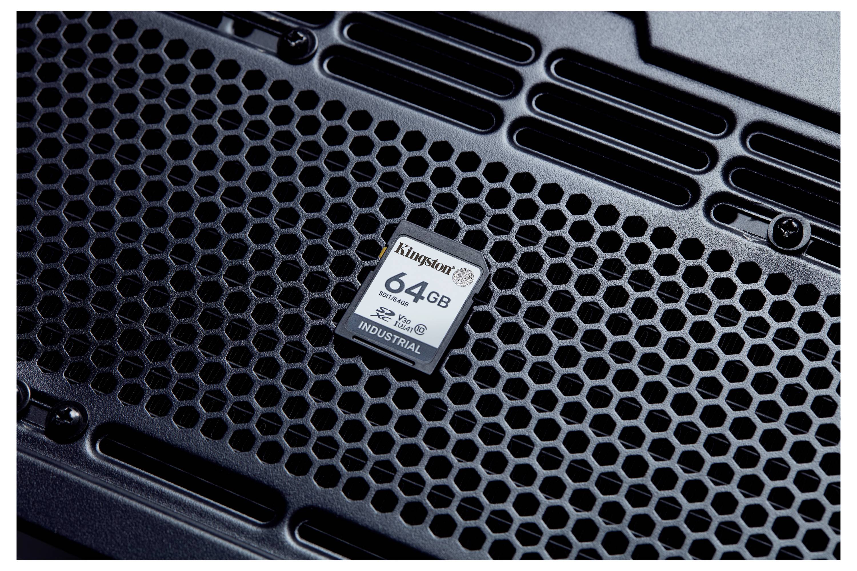 Gros plan d'une carte SD Kingston industrielle de 64 Go reposant sur une surface en métal en nid d'abeille noir.