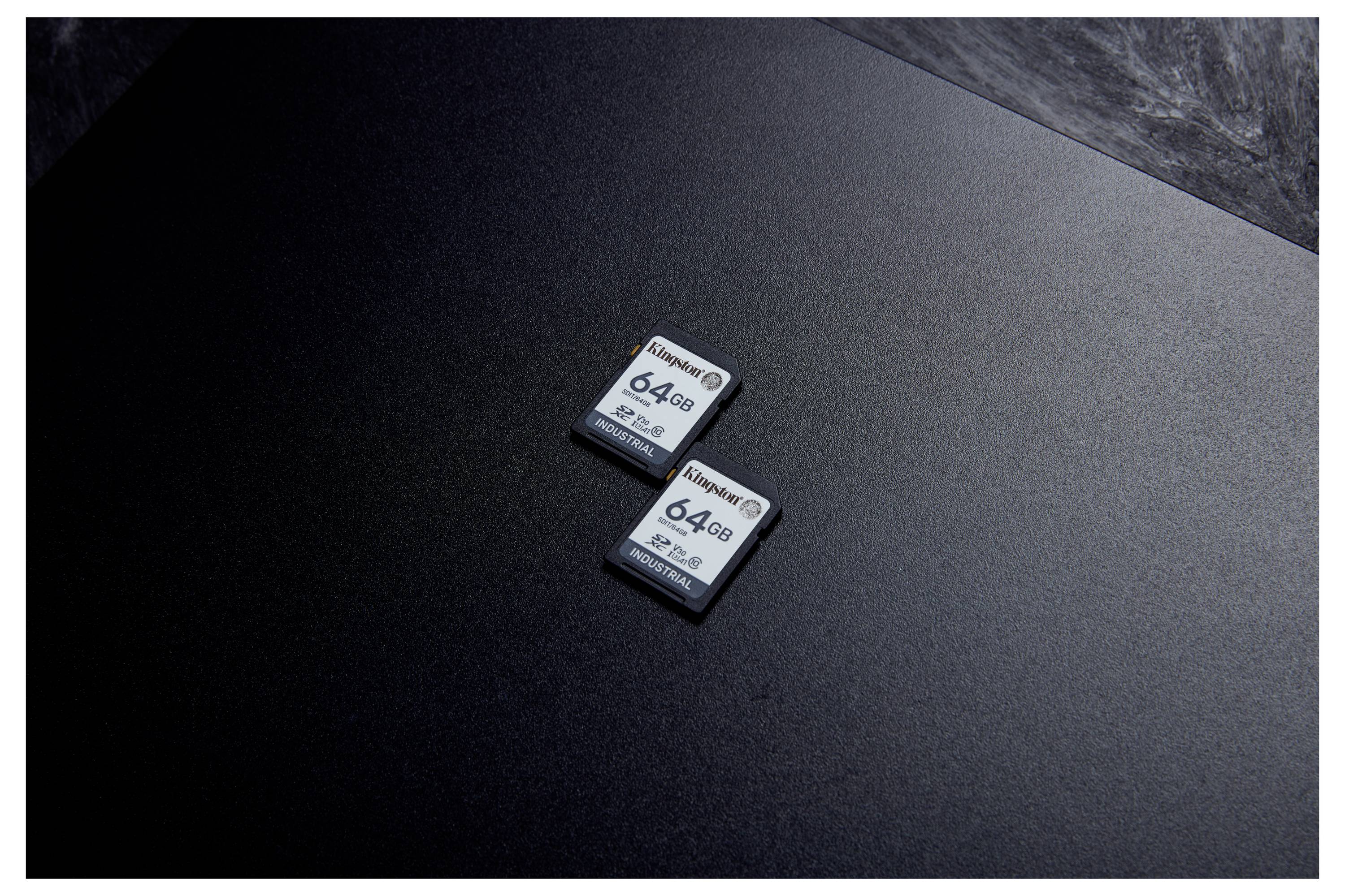 Deux cartes mémoire de 64 Go posées sur une surface sombre, vues de dessus.