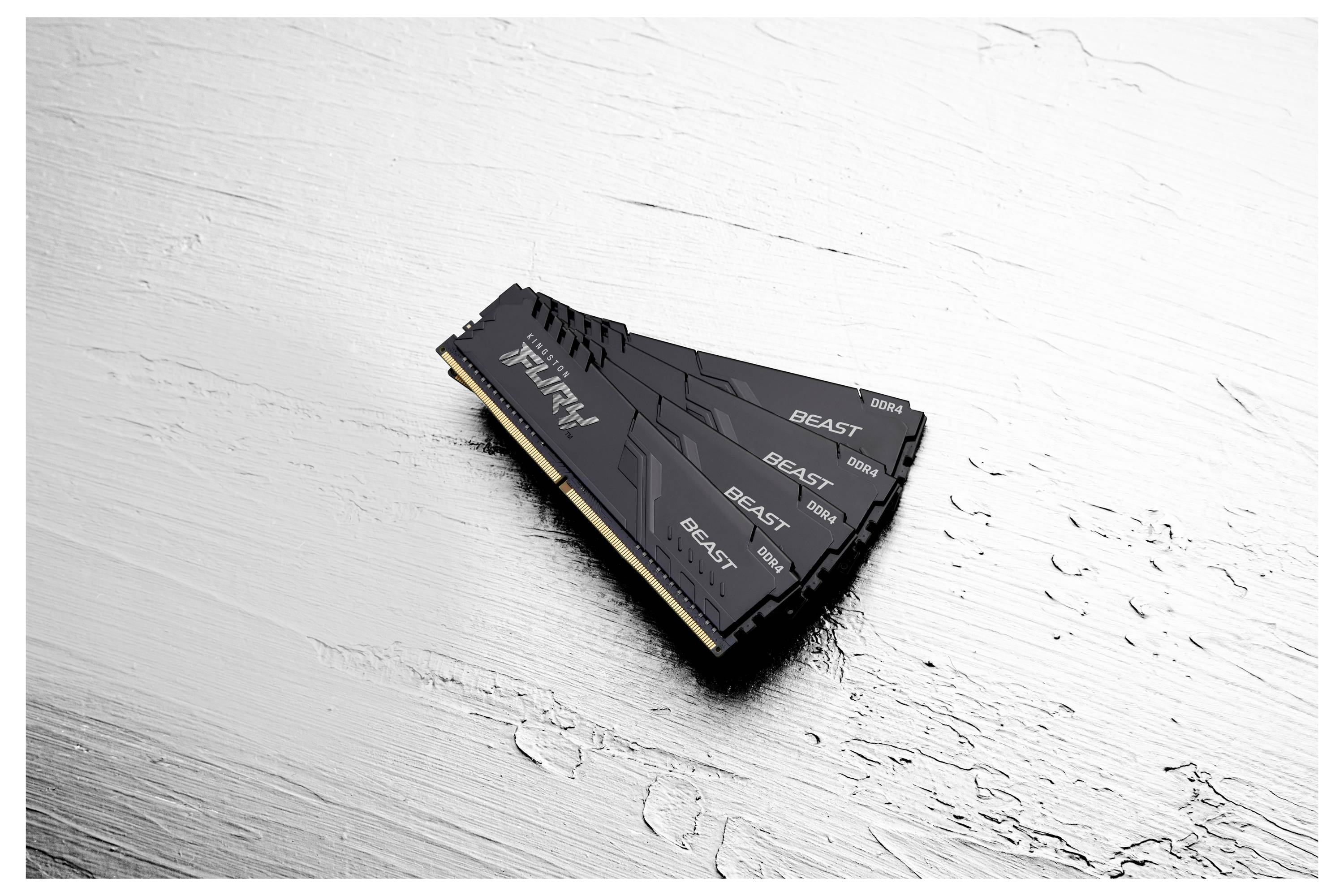 Gros plan d'un module de mémoire informatique Fury Beast noir, présenté en angle sur une surface texturée claire.