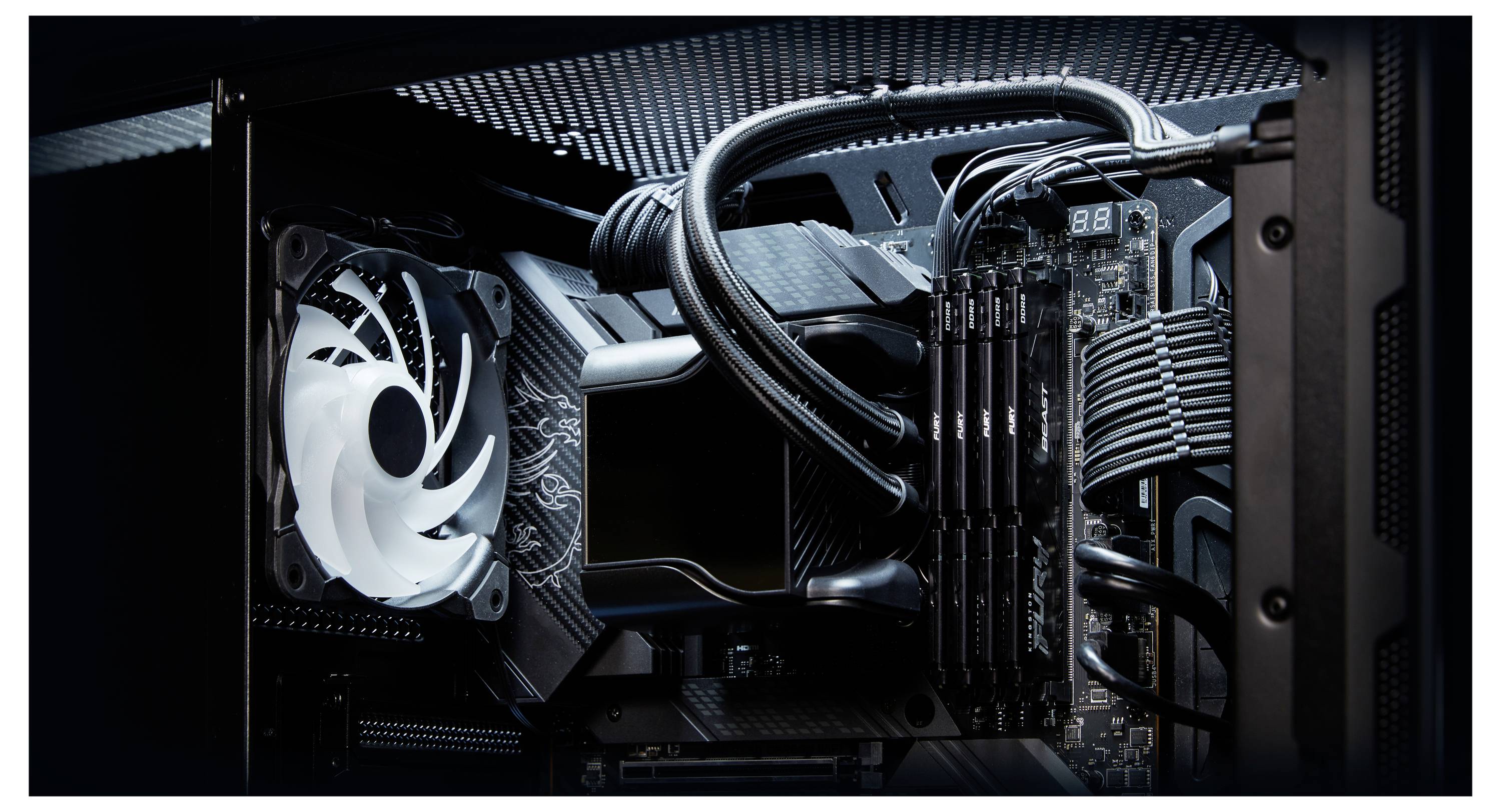 Intérieur d'un PC de bureau montrant une carte mère refroidie par liquide avec un bloc de pompe pour processeur, des barrettes de RAM, des tubes et un ventilateur de boîtier blanc.