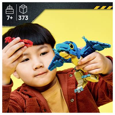 Enfant jouant avec un modèle d'oiseau de style LEGO ; la boîte indique un âge recommandé de 7+ ans et contient 373 pièces sur un fond jaune.