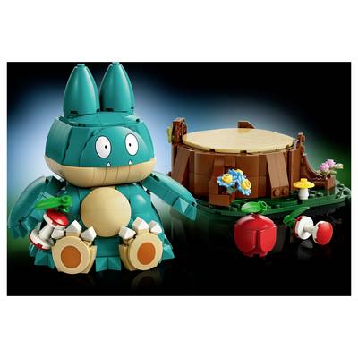 Figurine Bulbizarre de style LEGO à côté d'une scène de souche d'arbre avec des fleurs et des Poké Balls sur un fond noir.