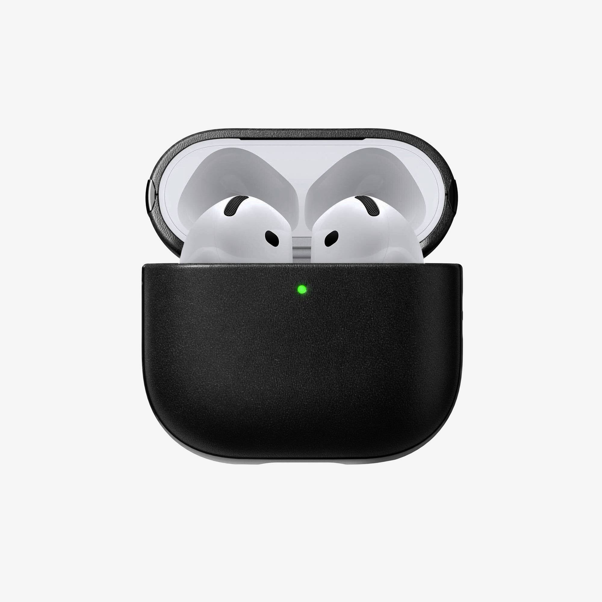 Étui de charge pour écouteurs sans fil noirs avec couvercle ouvert et voyant d'état vert, montrant les deux écouteurs blancs à l'intérieur sur un fond uni.