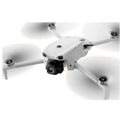 Drone quadcoptère blanc avec stabilisateur de caméra, montré en vol avec quatre hélices tournantes sur un fond uni.