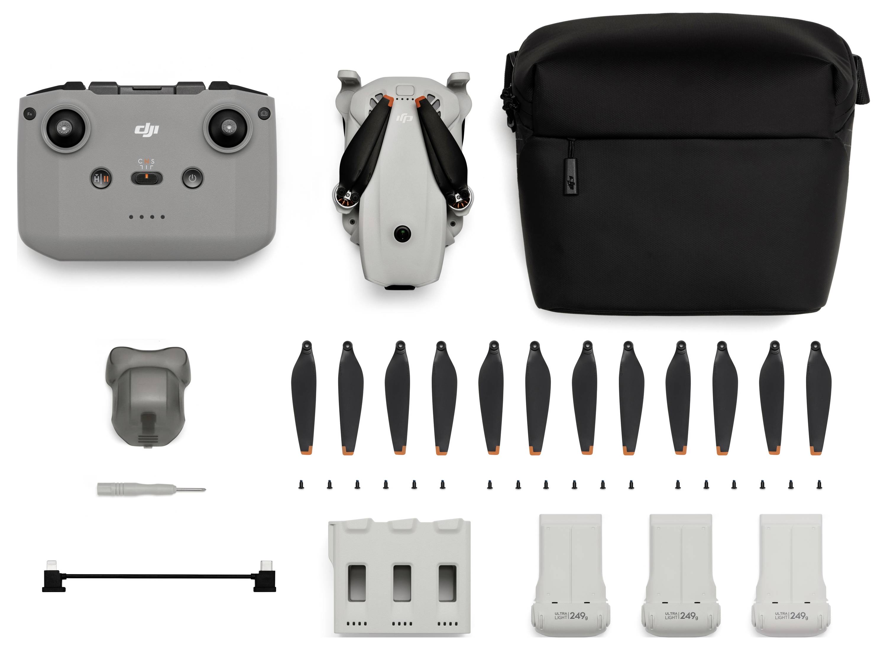 Kit de drone avec télécommande, drone plié, étui de transport, hélices multiples, outils, station de charge, et trois batteries.