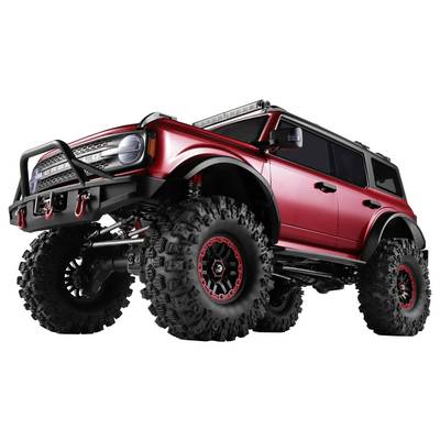 SUV tout-terrain rouge avec des pneus surdimensionnés, suspension surélevée et treuil avant, présenté dans une vue latérale de style studio.