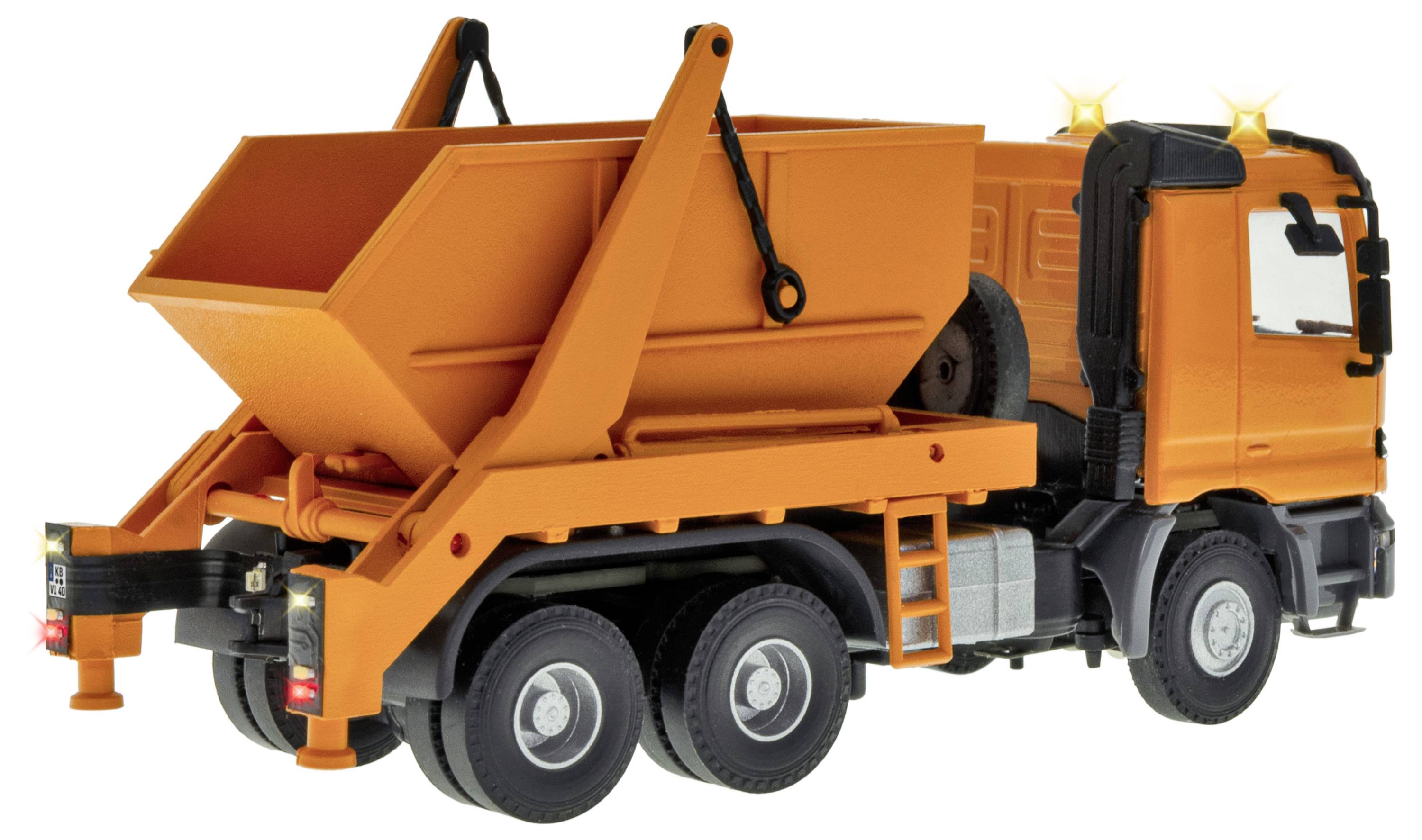 Camion benne orange avec plateau arrière relevé, présenté par l'arrière-gauche sur un fond blanc.