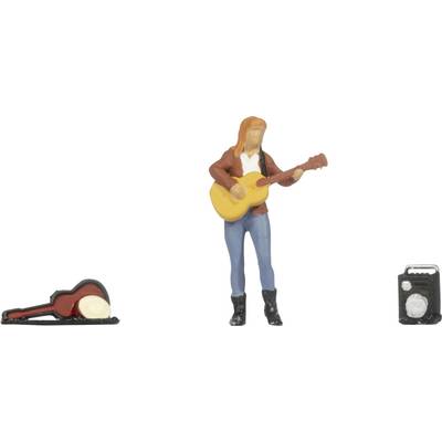 Figurine miniature de musicien jouant une guitare acoustique, avec un étui de guitare sur la gauche et un petit ampli ou haut-parleur sur la droite.