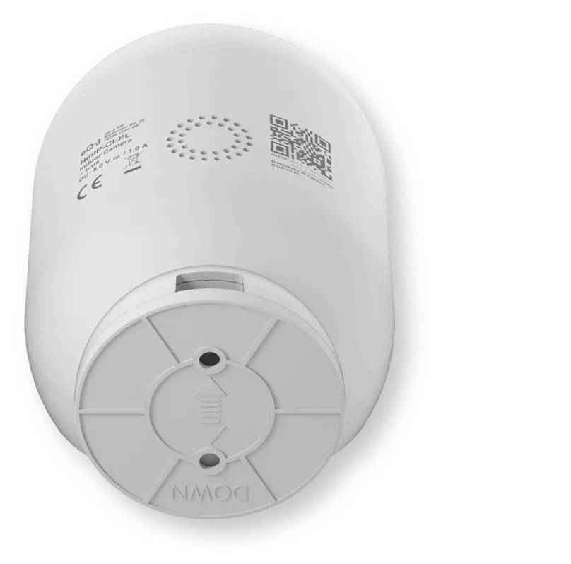 Dispositif électronique blanc de forme cylindrique, probablement un détecteur de fumée intelligent ou un capteur, présenté en gros plan sur un fond neutre avec un code QR et de petites étiquettes imprimées.