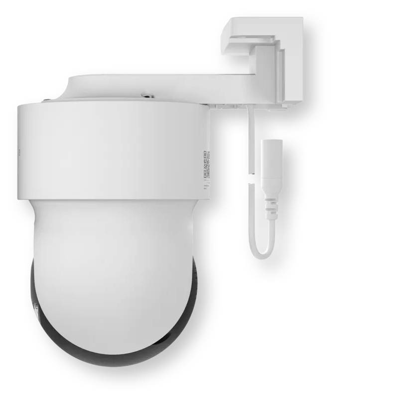 Caméra de surveillance montée en mur blanc avec un cache-objectif inférieur noir et un câble attaché sur un fond uni.