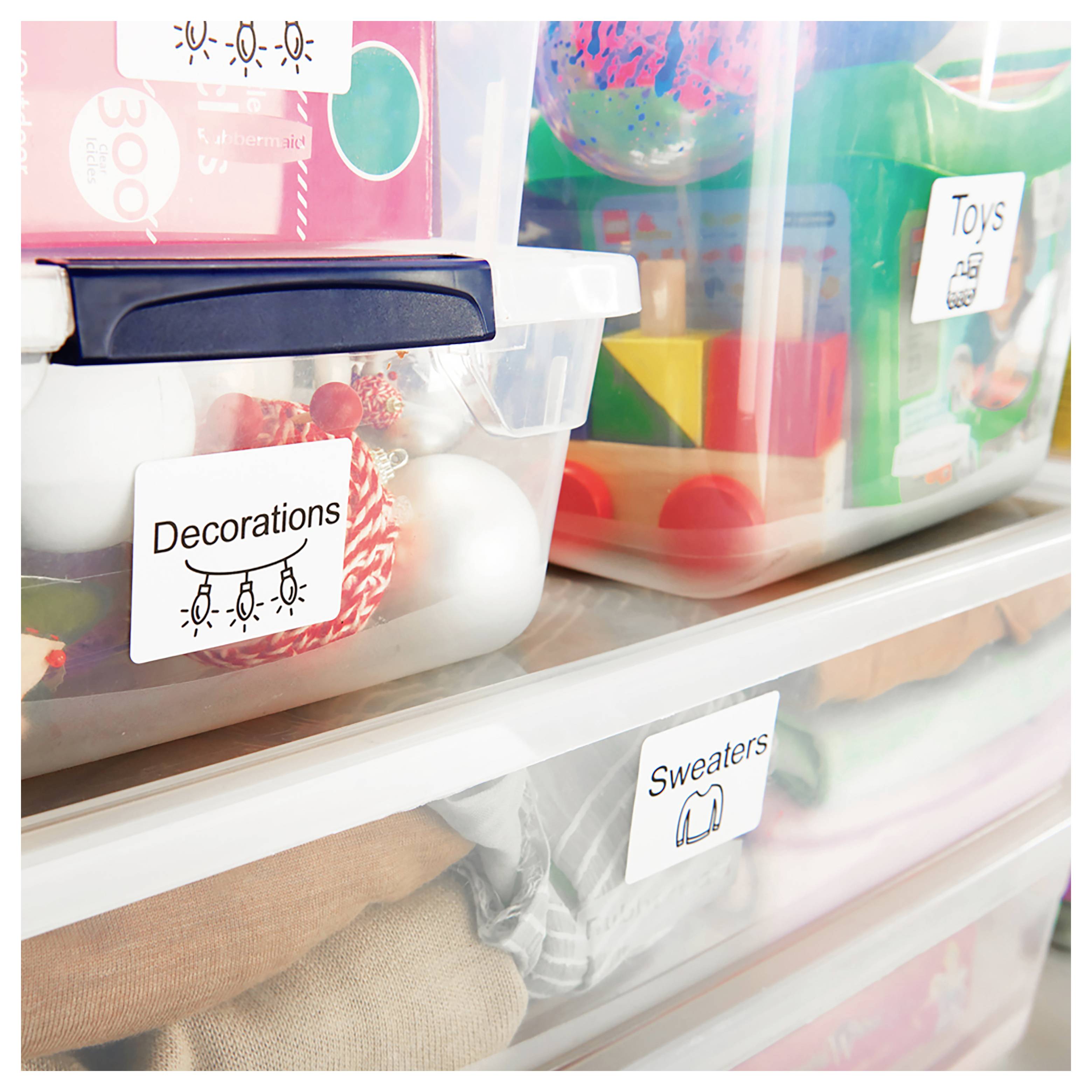 Bacs de rangement en plastique transparent sur des étagères étiquetés Décorations, Jouets et Pulls, organisant des articles de vacances assortis et des vêtements.