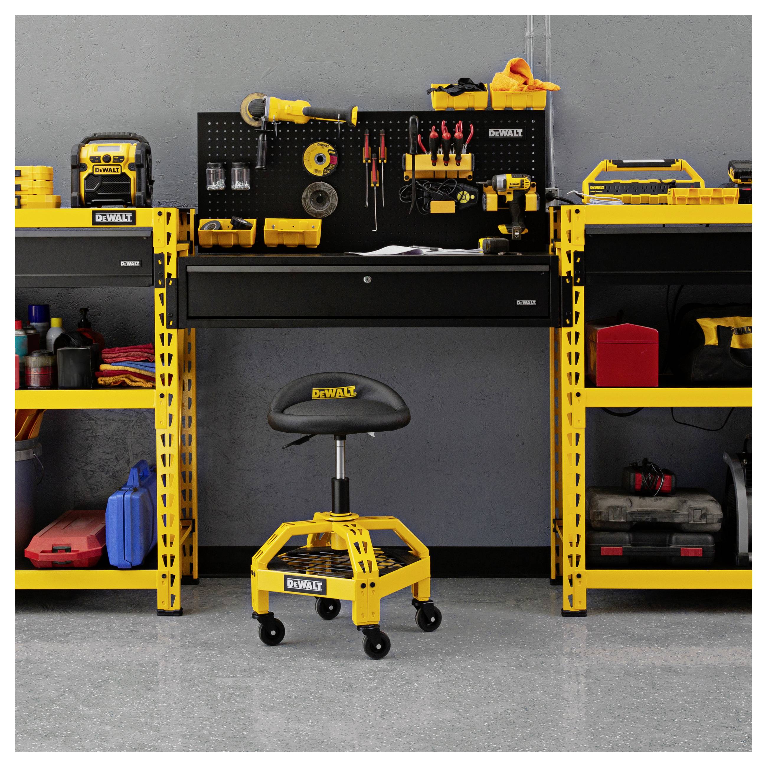 Configuration de rangement d'outils DEWALT jaune avec un panneau perforé mural, des étagères, un établi et un tabouret roulant d'atelier dans un garage.