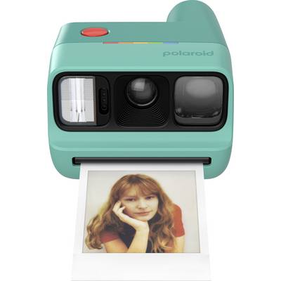 Un appareil photo Polaroid turquoise imprimant instantanément un portrait d'une jeune femme.