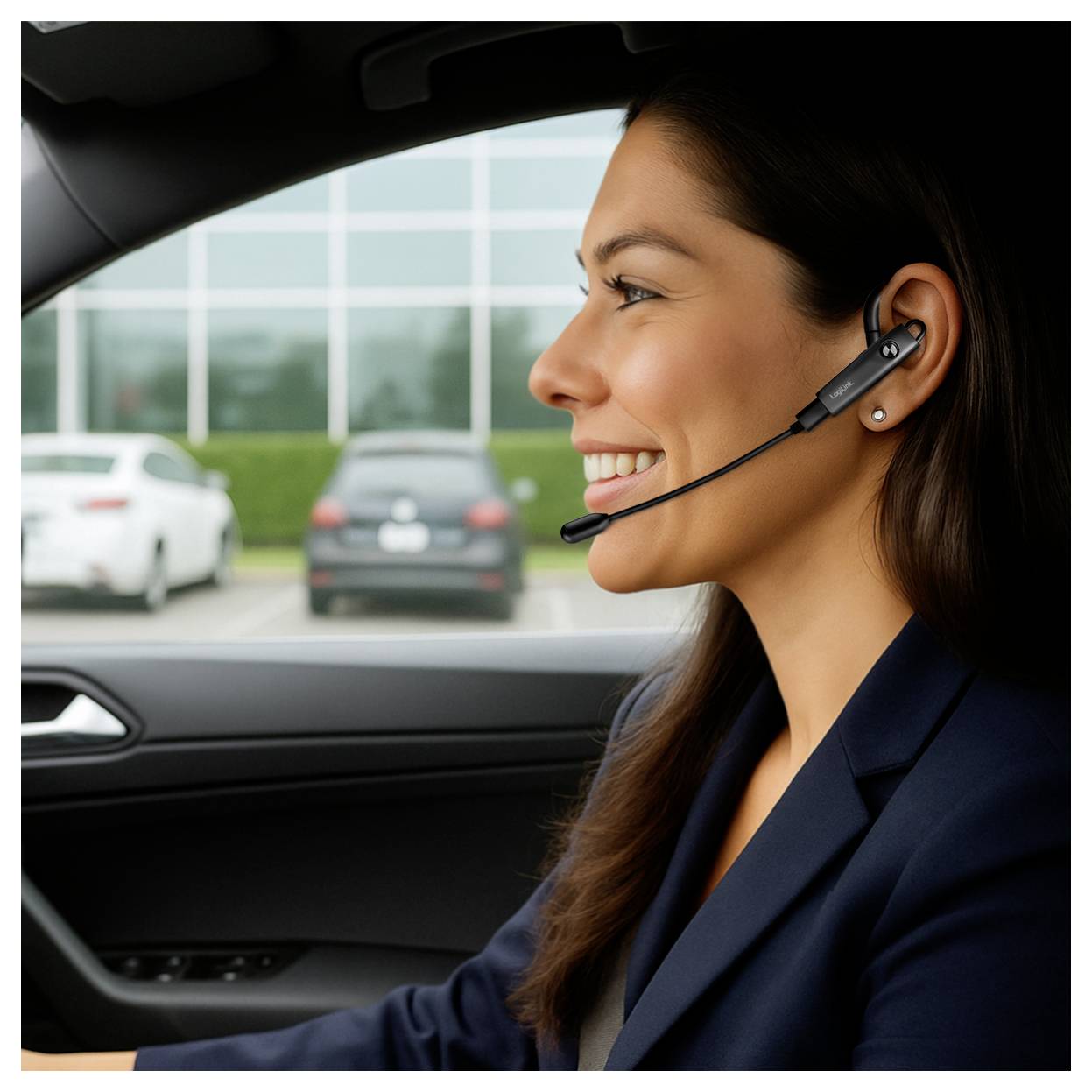 Femme souriante portant un casque qui conduit une voiture, probablement en train de prendre un appel du service client.