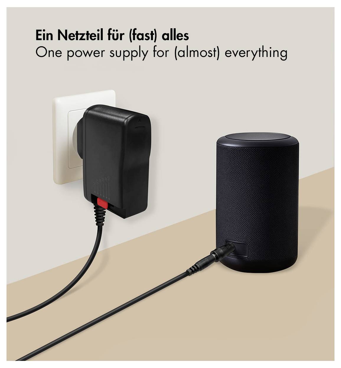 Une alimentation pour (presque) tout<br><br>Un chargeur mural alimentant un haut-parleur cylindrique noir, avec le titre « Une alimentation pour (presque) tout » en allemand et en anglais.
