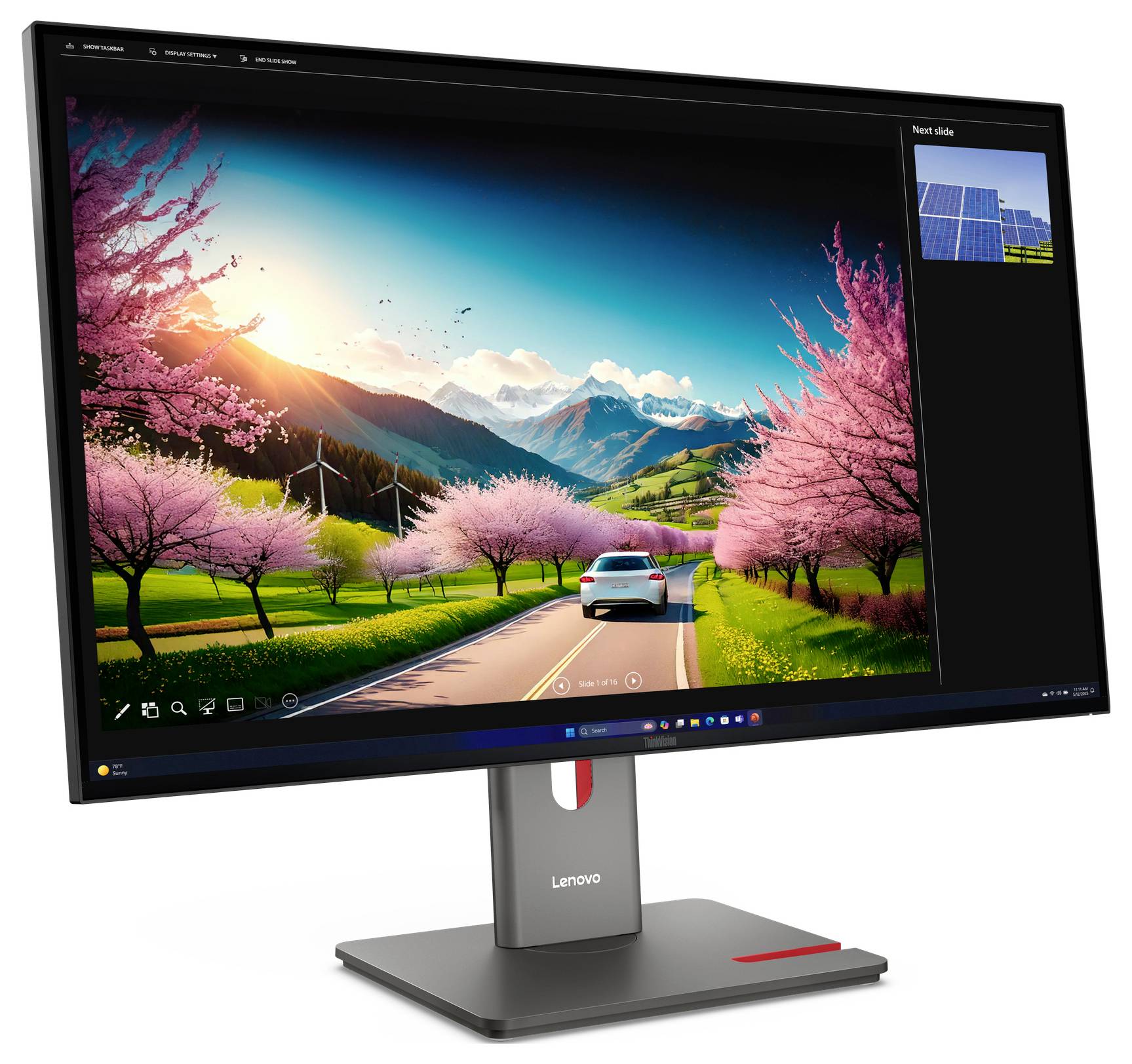 Moniteur Lenovo affichant un fond d'écran paysager éclatant d'une voiture roulant sur une route à travers des arbres en fleur rose en direction des montagnes au coucher du soleil.