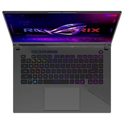 Vue de dessus d'un ordinateur portable gaming ASUS ROG avec un clavier RGB illuminé et un grand pavé tactile, affiché ouvert sur un écran avec thème ROG néon.