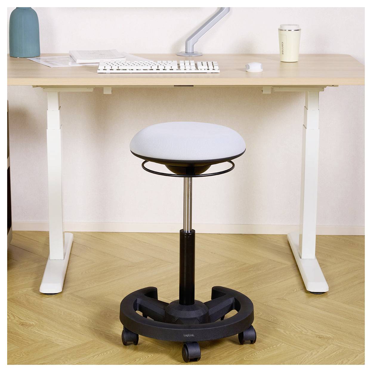 Tabouret réglable sur roulettes centré sous un bureau debout dans un bureau à domicile minimaliste.