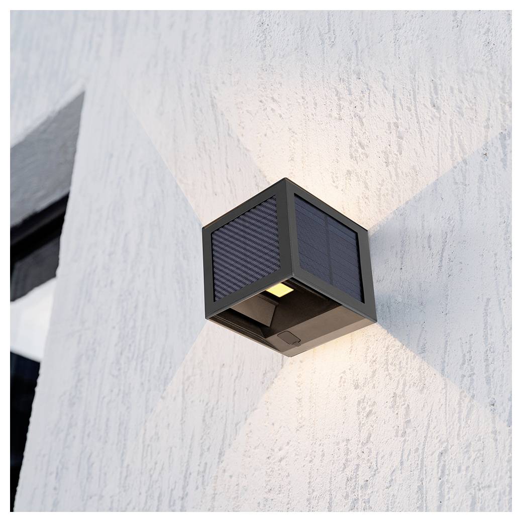 Applique murale extérieure noire moderne montée sur un mur blanc texturé, projetant une lumière douce vers le haut et vers le bas.