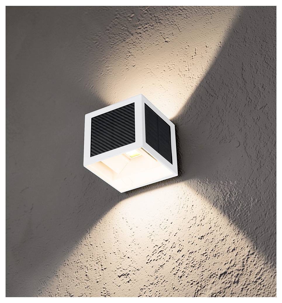 Luminaire cube blanc moderne monté en applique murale projetant des faisceaux chauds vers le haut et vers le bas sur un mur texturé.