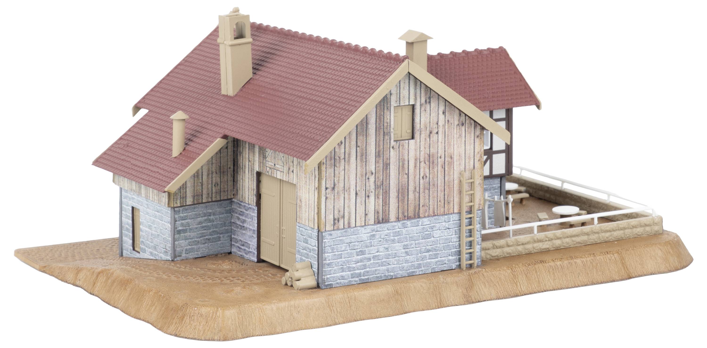 Modèle 3D d'une petite maison rustique avec toit rouge, revêtement en bois, base en pierre, et une terrasse latérale clôturée sur une plateforme de base