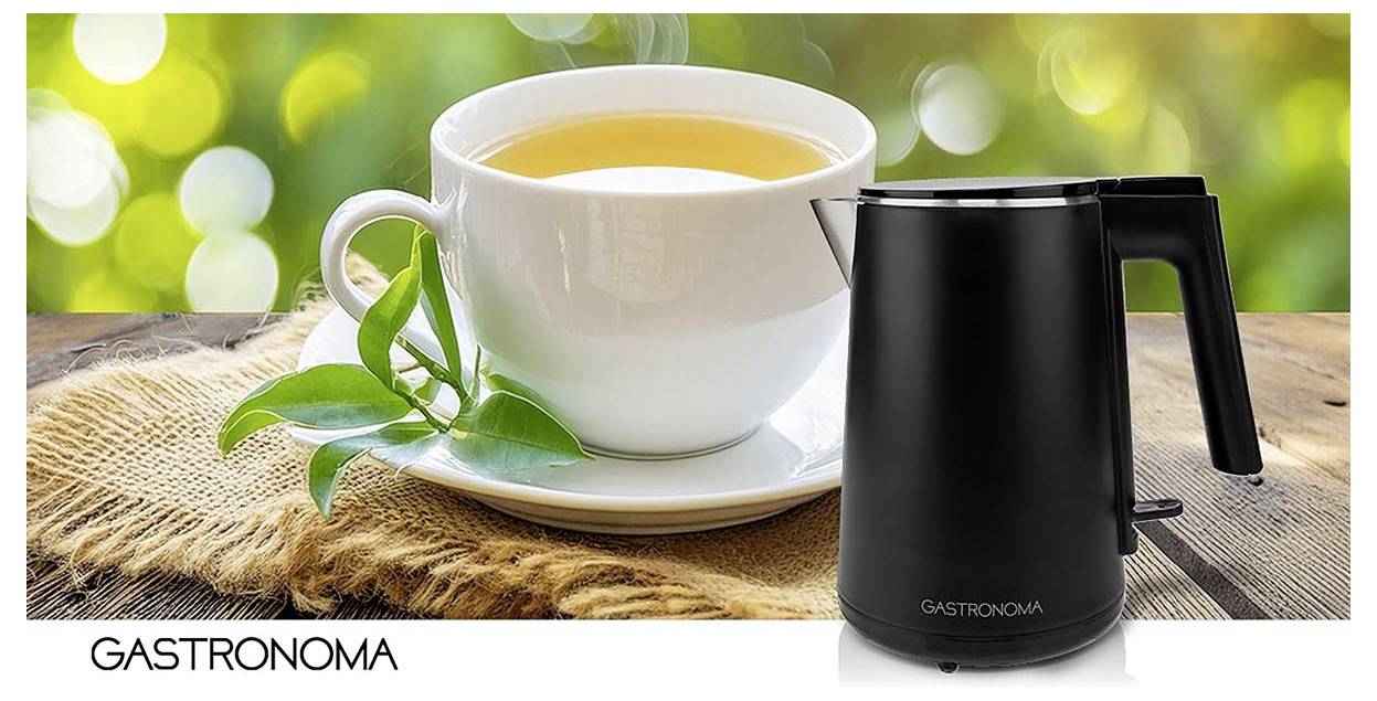 Image promotionnelle d'une tasse à thé blanche sur une soucoupe avec des feuilles vertes à côté d'une bouilloire électrique Gastronomia noire sur une table rustique.