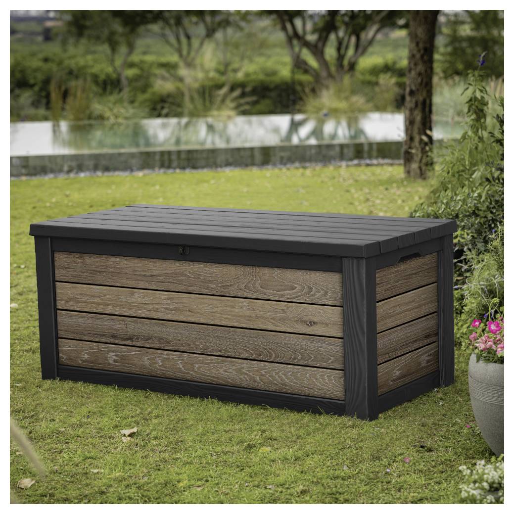 Boîte de rangement extérieure en bois avec cadre noir et couvercle à lames assis sur une pelouse herbue