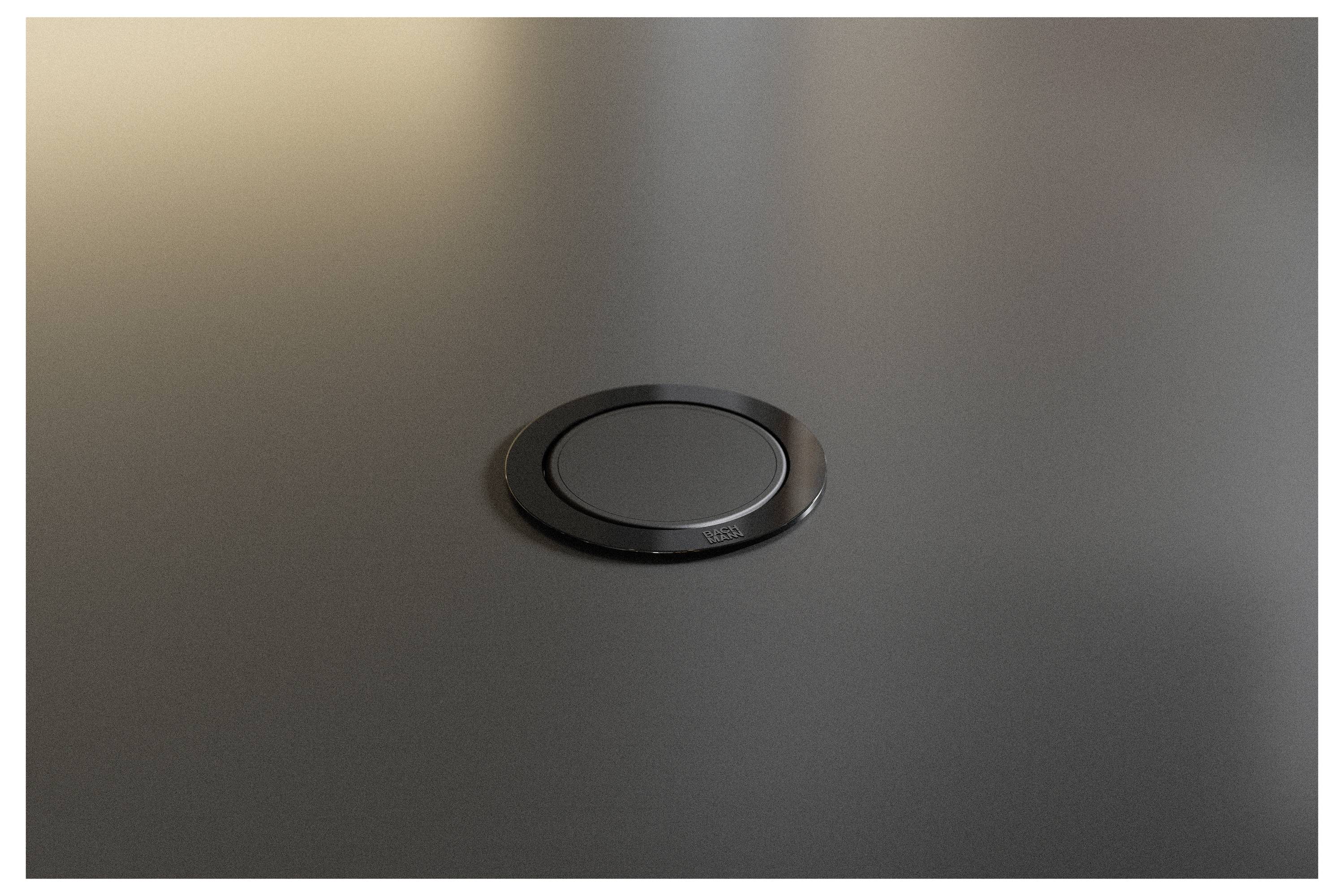 Gros plan d'un plateau de bureau ou de table en noir mat avec un cache de câble circulaire ou un couvre-port centré.