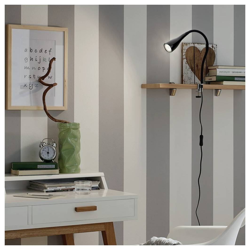 Coin de bureau à domicile élégant avec papier peint rayé, art alphabet encadré, lampe de bureau, étagères, livres, horloge et vase décoratif.