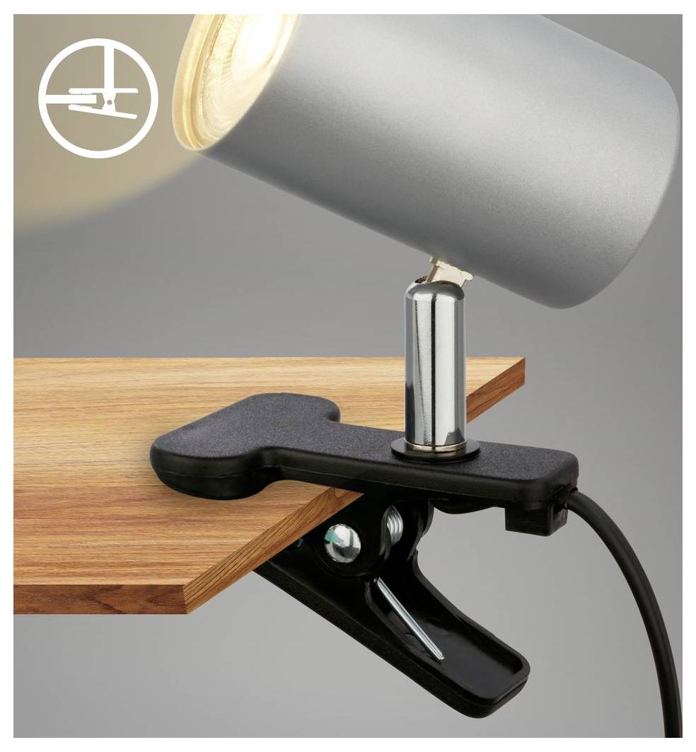 Projecteur à pince noir fixé à un bureau en bois, avec une tête de lampe argentée ajustable et un cordon d'alimentation, montrant une pince de montage sécurisée.