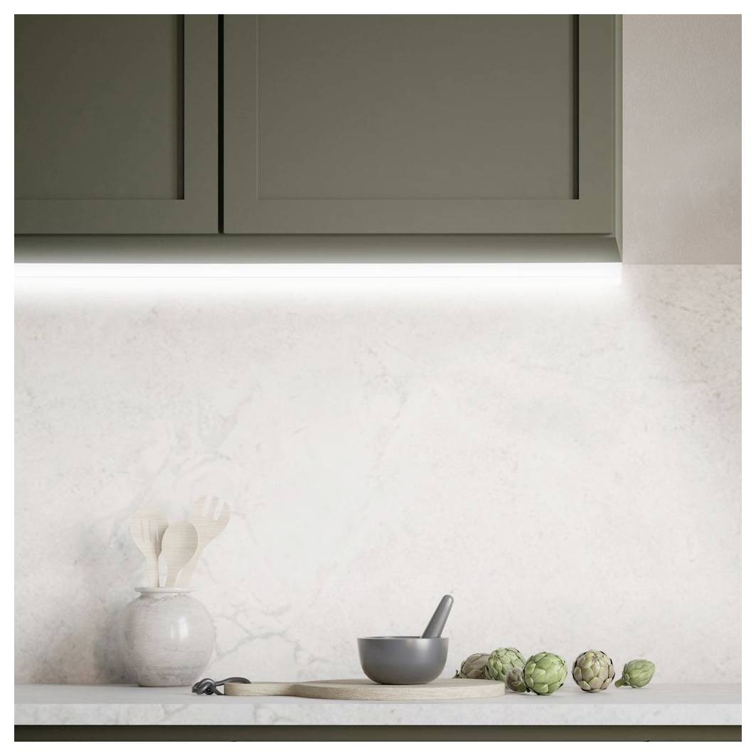 Comptoir de cuisine minimaliste avec un mortier et un pilon, une cuillère en bois, un vase d'ustensiles et des artichauts sous les armoires supérieures.