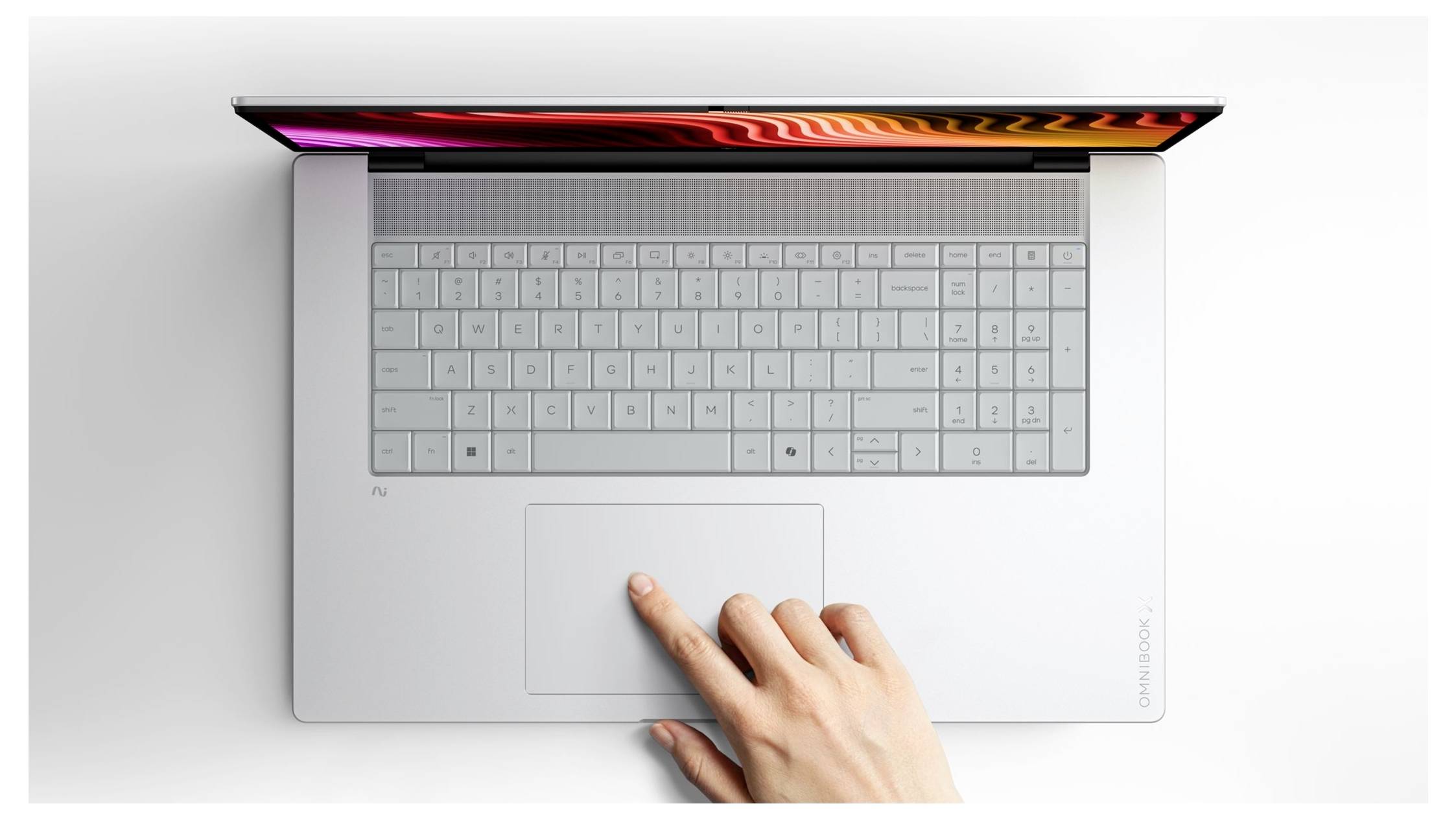 Vue de dessus d'un ordinateur portable avec le clavier visible et une main utilisant le pavé tactile.